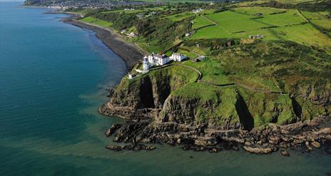 Aerial view of Blackhead Coastal Path and Lighthouse with surrounding countryside