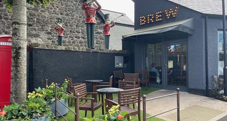 Exterior of Brew Coffee Shop with seating area and herald trumpeters