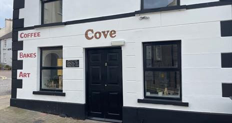 Black and White exterior of Cove Coffee Shop with words painted for Coffee Bakes and Art