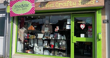 Green shop front of Jenni Mac Gifts & Crafts with window display of crafted items