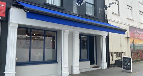 Exterior of Luna Cafe / Bar in Carrickfergus with blue canopy and white pillars