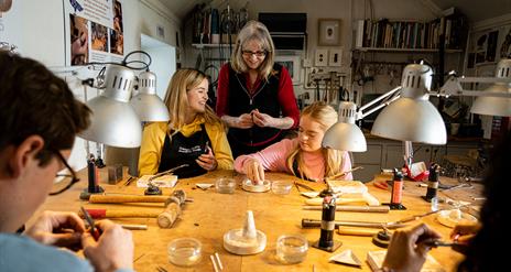 Instructor watching over the group as they make jewellery as part of the workshop with Gobbins Craft in Islandmagee