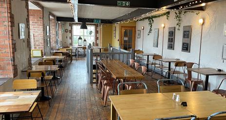 Interior of Season Coffee Shop with wooden flooring, wooden beams and wooden tables plus chairs.