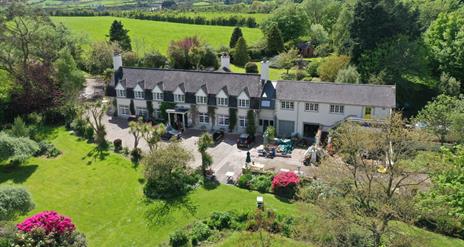 Aerial view of the house and grounds showing lawns to the front of the property