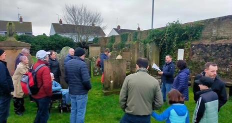 Alastair Donaghy leading a Ballymena Walking Tour with tour participants standing in a graveyard