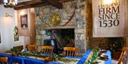 Room set up for Dobbins dining experiece as part of Dobbins Dander and Dine with seats and long tables in front of a large fireplace.