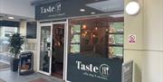 Grey and white exterior of Taste Coffee Shop & Restaurant