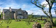 View of BallyCairn House from front garden. Situated on an elevated, picturesque location overlooking the Irish Sea with backdrop views of the Antrim