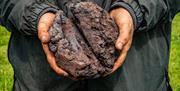 Someone holds a lump of cooled iron just made in a furnace