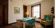 Dining room. There is a table with four chairs and in one corner a cosy armchair.