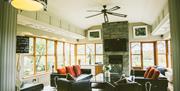 Red Oaks Residence living area with spacious surroundings that include sofas, armchairs and large windows that look out towards the rolling countrysid