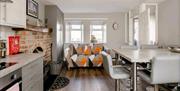 Open plan sitting area with kitchen table front door and a fireplace.