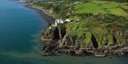 Aerial view of Blackhead Coastal Path and Lighthouse with surrounding countryside