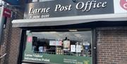 Exterior of the Book Nook in Larne with signage to promote Larne Post Office, Larne Visitor Information Point and MoneyGram