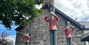 Herald trumpeters on roof adjacent to Brew Coffee Shop