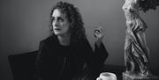 Briana Corrigan seated at a table with a cup of coffee.