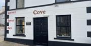 Black and White exterior of Cove Coffee Shop with words painted for Coffee Bakes and Art