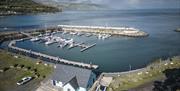 Aerial view of blue Glenarm Tourism building with marina in the background