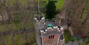 A drone view of the top of the Barbican gatelodge. There is a green picnic table on the top of the tower for outdoor dining.