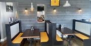 Private seating booths with nautical decorations on walls in Harbour Lights cafe in Carnlough