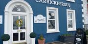 Blue and white exterior of Javart Gift Shop with potted plants