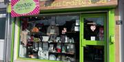 Green shop front of Jenni Mac Gifts & Crafts with window display of crafted items