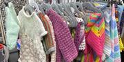 Rail of knitted children's clothes and blankets