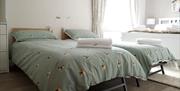 Two foldig beds with light green bedspreads and towels in Loughview Lodge