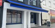 Exterior of Luna Cafe / Bar in Carrickfergus with blue canopy and white pillars