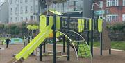 Children's green slide and play equipment at Marine Gardens Play Park