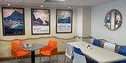 Seating area within Prom Cafe with vintage tourism posters on the wall