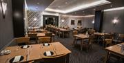 Interior of restaurant at Ross Park Hotel with wooden seats and tables