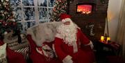 A photo of Santa in his Whitehead grotto waiting for children to arrive for presents.