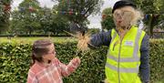 Little girl staring at speed cop scarecrow at Gracehill Scarecrow Competition