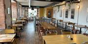 Interior of Season Coffee Shop with wooden flooring, wooden beams and wooden tables plus chairs.