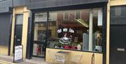 Yellow and Black exterior of the Wee Cafe Larne with name on window and silver outdoor seats