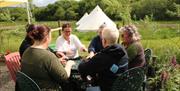A group sit around a table 'walking' woven fabric