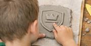 child using clay to make a crest