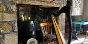A traditional Scottish harp sitting in a rustic room with stone walls, and beside it is a traditional Irish bódhran. The room is lit with candles and