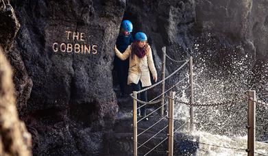 Couple walking through the arch at The Gobbins Cliff Path