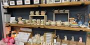 Range of pottery items and pictures displayed on shelves at 2020 Art