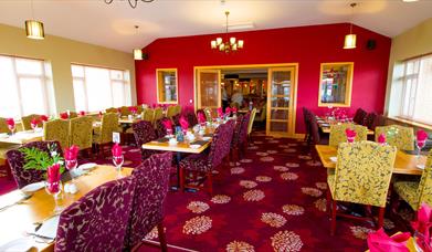Dining area within Curran Court Hotel restaurant with a purple and pink decor.