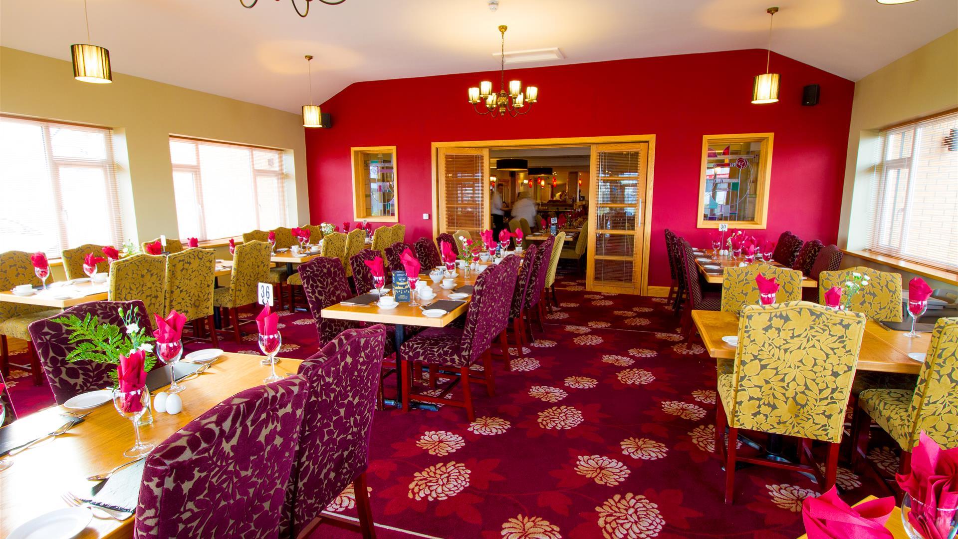 Dining area within Curran Court Hotel restaurant with a purple and pink decor.