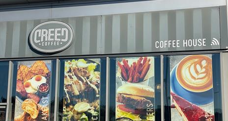 Exterior of Creed Coffee House in Carrickfergus with banners in windows displaying food options