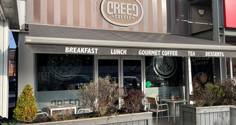 Exterior of Creed Coffee in Larne with outdoor seating area, and grey canopy