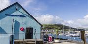 Blue Glenarm Tourism building in foreground with marina in background