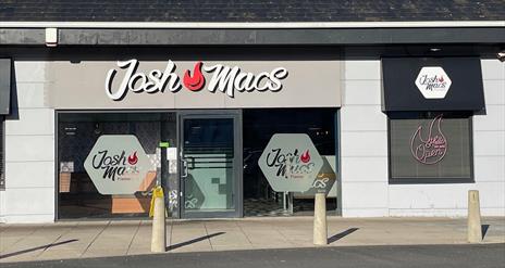 Josh Macs restaurant exterior with sign, large windows and door entrance,