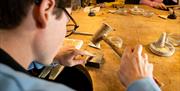 Man with a mallet moulding a ring as part of the jewellery making workshop with Gobbins Crafts in Islandmagee