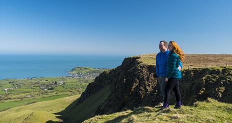 Walkers looking over cliff top at Sallagh Braes
