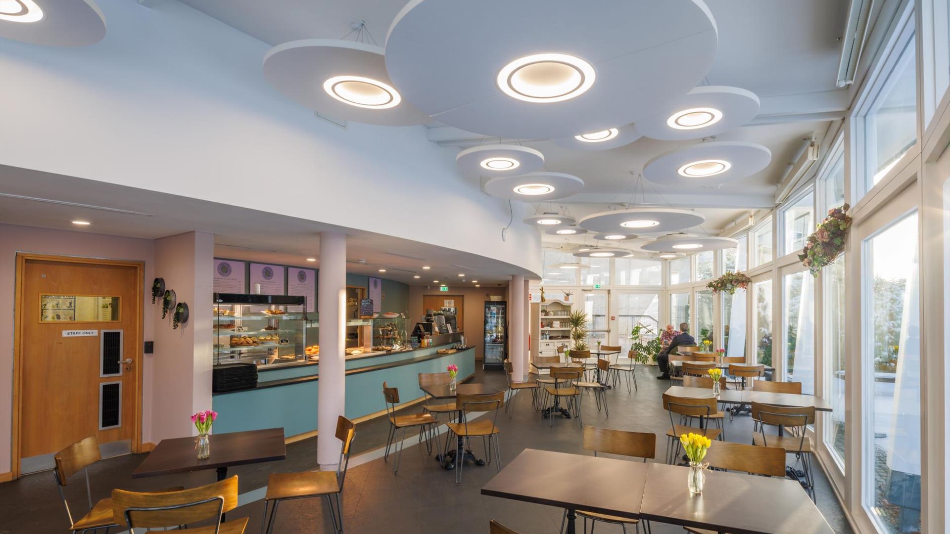 Serving counter and tables and chairs in main eating area of the The Secret Garden Cafe